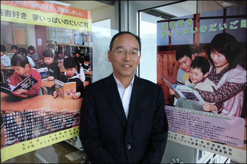 일본 이바라기현의 다이고 마치는 마을 모든 주민이 활발한 책읽기 활동을 펼치는 ‘독서 마을’이다. 다이고 마치의 와타히키 히사오 정장(사진 가운데)이 청사 앞 독서운동 포스터 앞에서 독서운동을 설명하고 있다.