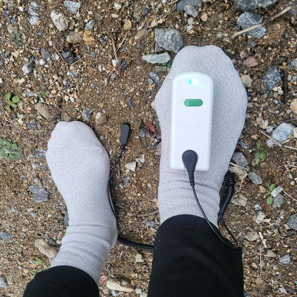 약손월드 '어싱양말'의 전도성 테스트를 하면 ''파란불'이 켜진다. 땅속의 음전자가 연결되어 맨발걷기 효과를 내는 접지효과가 있음이 입증된 것이다.