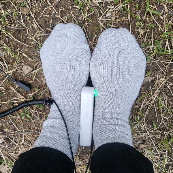 약손월드 '어싱양말'의 전도성 테스트를 하면 ''파란불'이 켜진다. 땅속의 음전자가 연결되어 맨발걷기 효과를 내는 접지효과가 있음이 입증된 것이다.