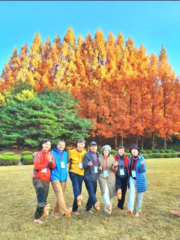 김지율 영맨발러 지회장(왼쪽)이 맨발걷기국민운동본부 회원들과 함께 어싱을 하고 있다.