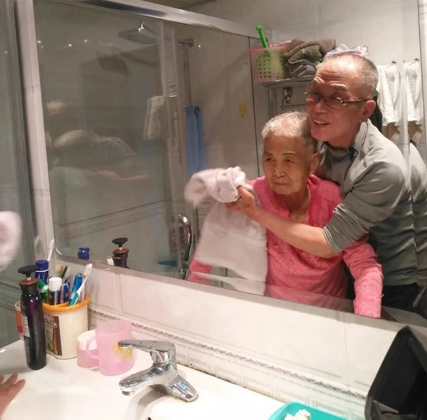 수필 '엄마손의 1원짜리'에 첨부된 사진. "어머니의 머리를 감겨 드리고 씽크대 앞에서 웃음을 유발해 보려고 애쓰던 행복한 시절"이란 사진설명이 적혀 있다.