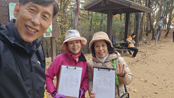 남양우 지회장(왼쪽)이 맨발번들과 함게 시민 서명지를 들어보이고 있다..(맨발걷기국민운동본부 제공)