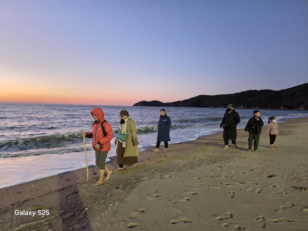 21일 하나개해수욕장에서 맨발걷기 송년회를 마친 맨발벗들이 해변을 맨발로 걷고 있다.