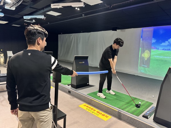 샘 리(왼쪽)가 골프 레슨을 하는 장면.