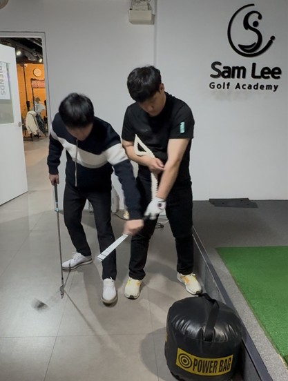 샘 리(오른쪽)가 골프 레슨을 하는 장면.