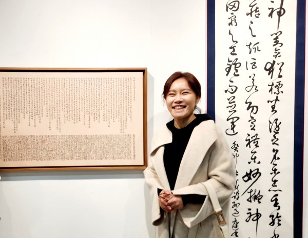 연정(蓮汀) 정용남 서예가가 자신의 서예 작품 앞에서 환하게 웃고 있다. 정 서예가는 내달 12일부터 18일까지 서울 인사동 백악미술관에서 한글과 한문 서예, 사경 등 다양한 작품 50점을 선보이는 개인전을 연다.